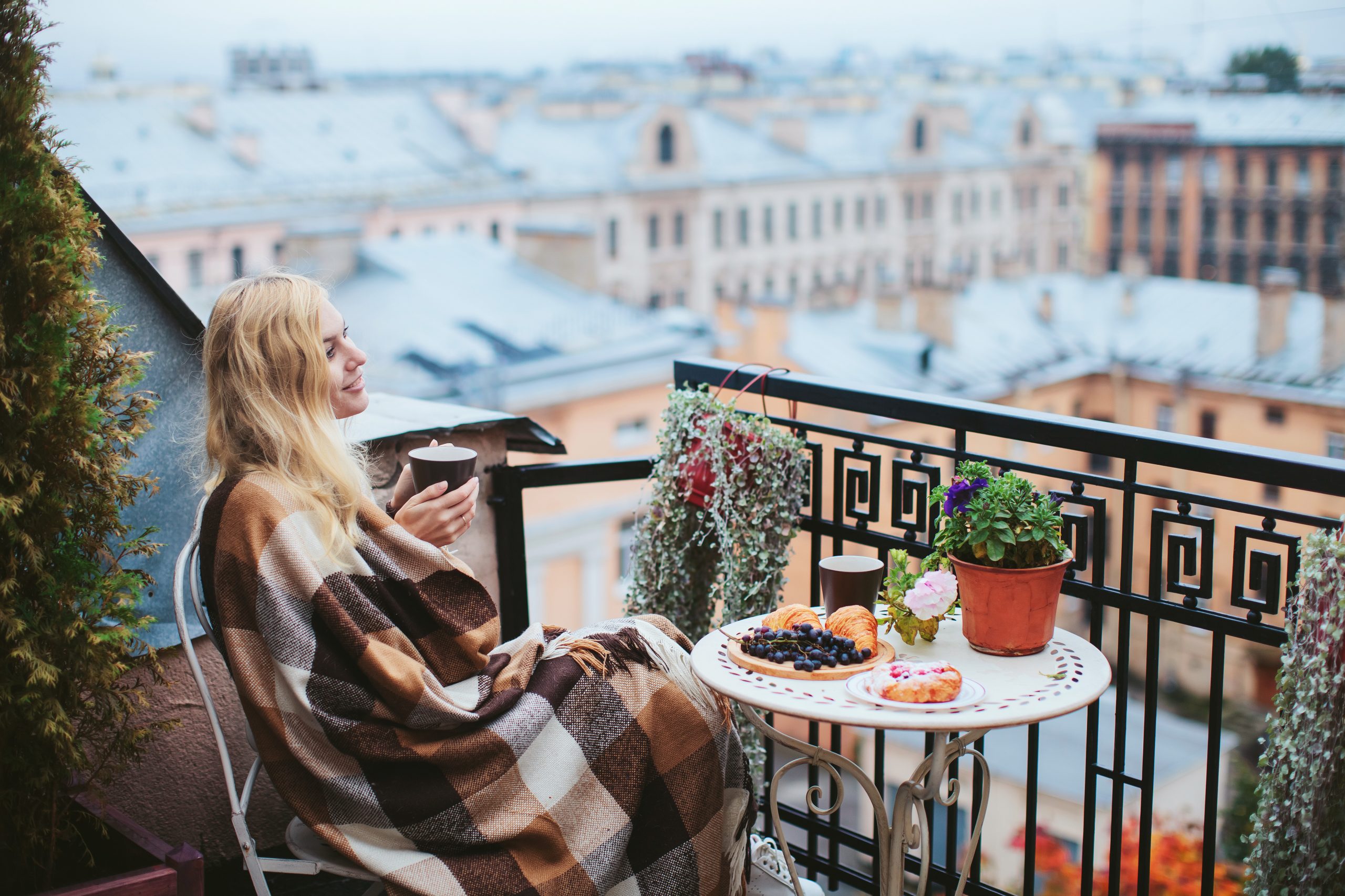 Chica tomando desayuno en su terraza de invierno