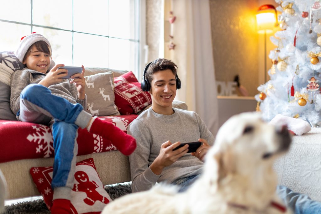 Hermanos jugando con sus móviles tras recibir los regalos de Reyes.